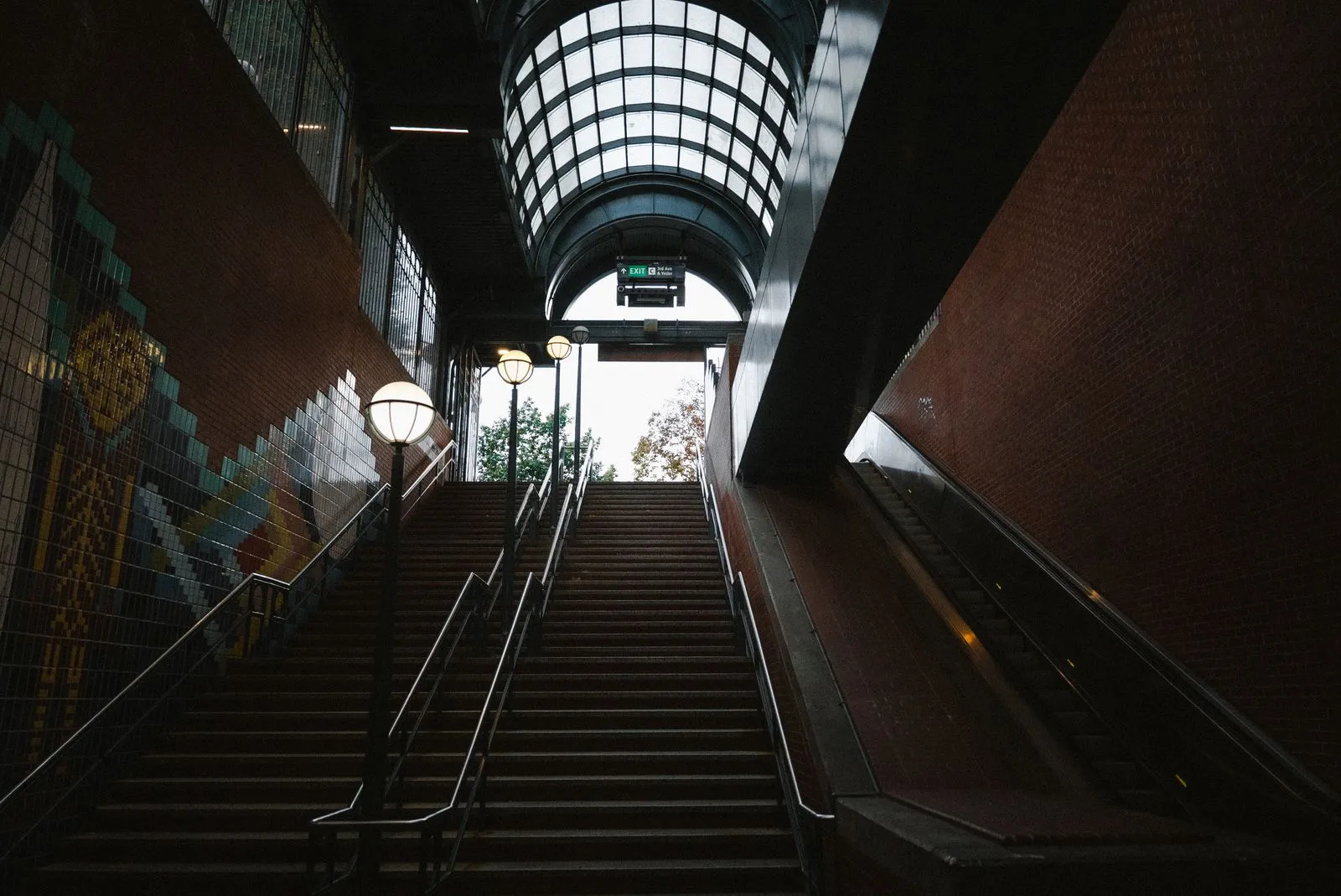 View from an underground station exit with stairs and an escalator in Seattle.
